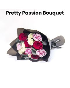 A Hand Bouquet Of Red And Pink Roses Wrapped With Black Wrapping